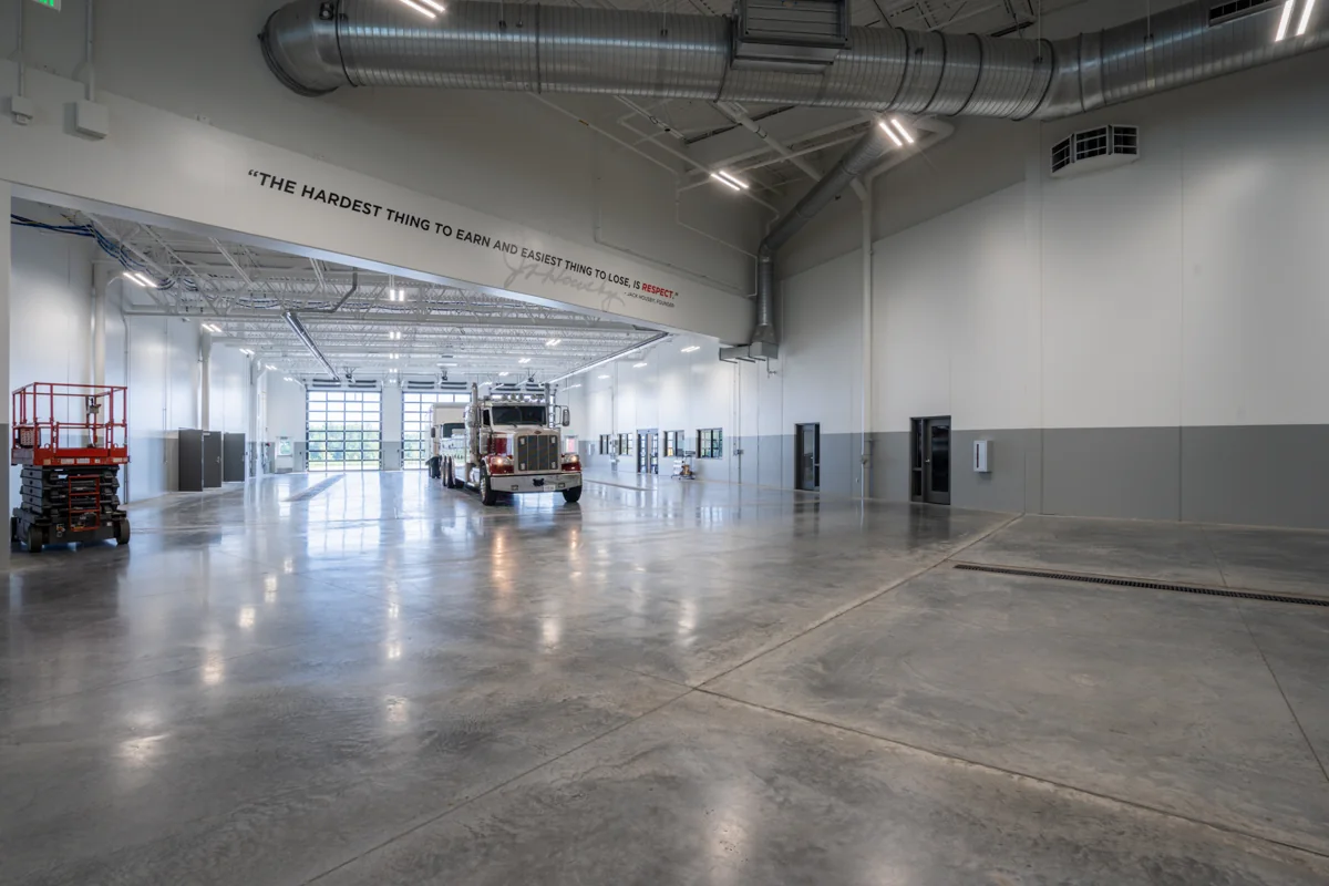High-bay truck service intake area with ventilation and linear lighting.