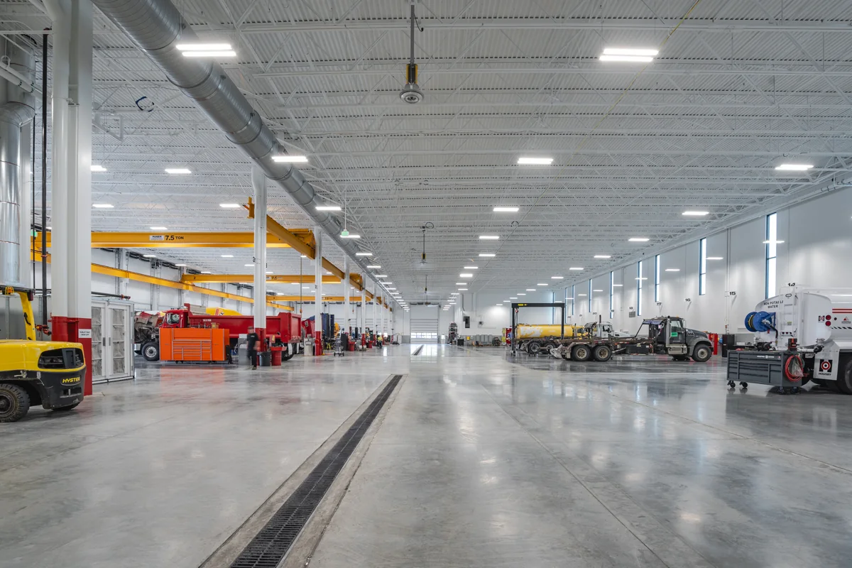 Housby Mack main service floor with heavy vehicles, overhead cranes, ventilation, and lighting.